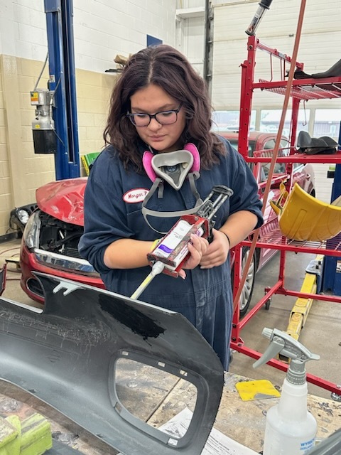 Female student glue part in Auto Body Tech